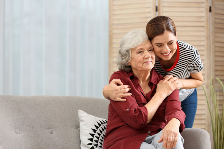 Elderly woman with daughter in living room.