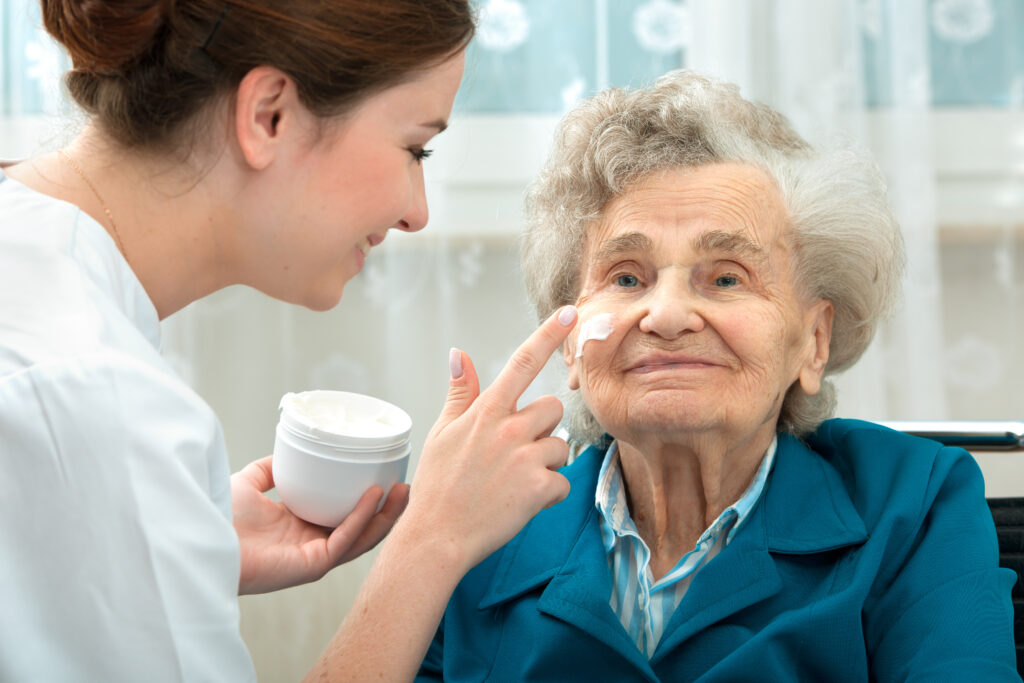 Nurse applying cream to patients face
