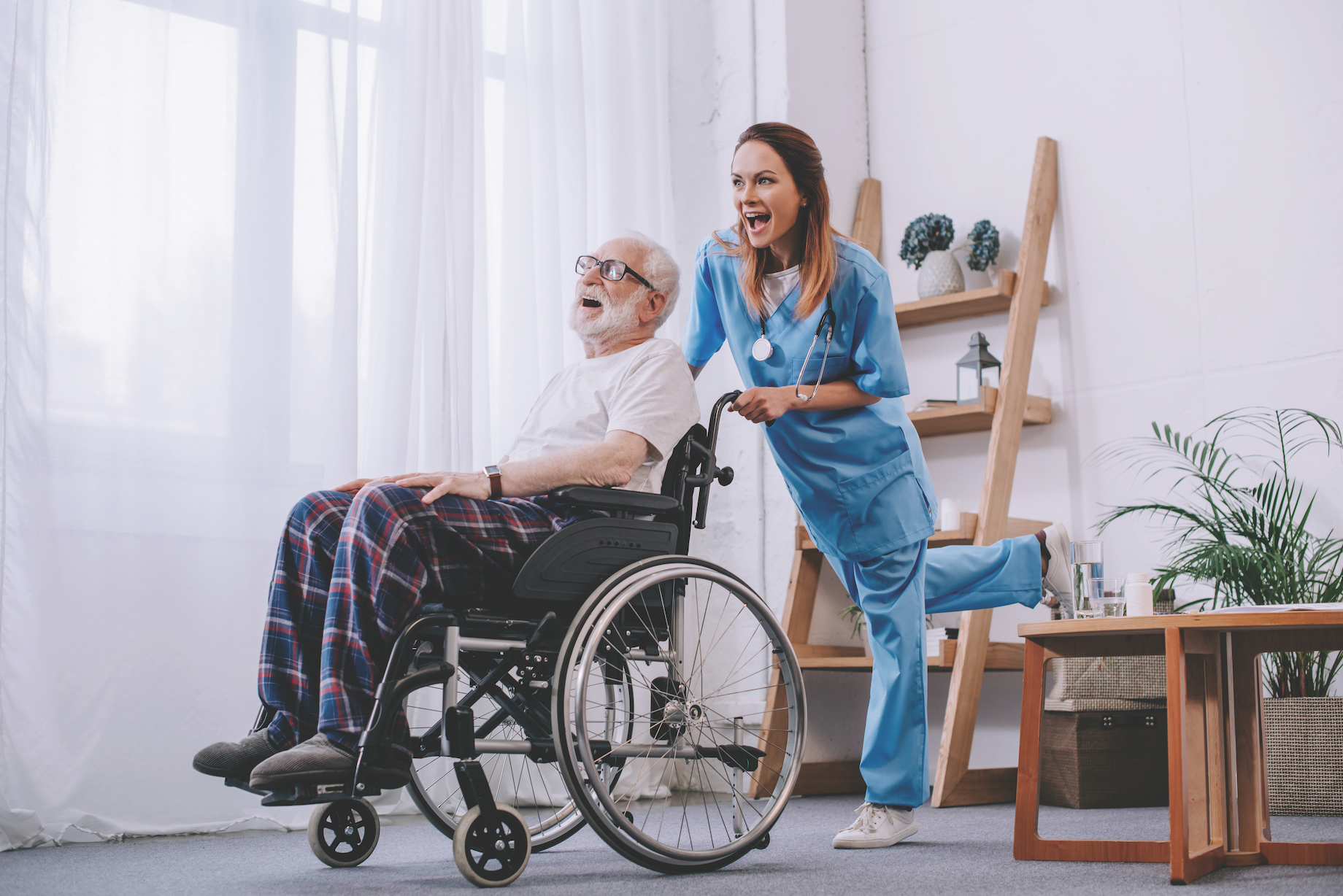 Nurse and senior patient in wheelchair having fun