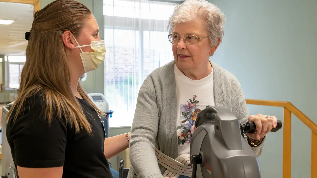 Lakeland therapist helping female senior use a rehab machine