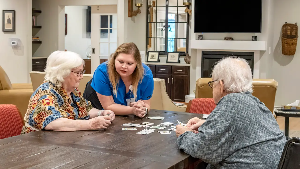 Estoria staff member talking to residents playing cards