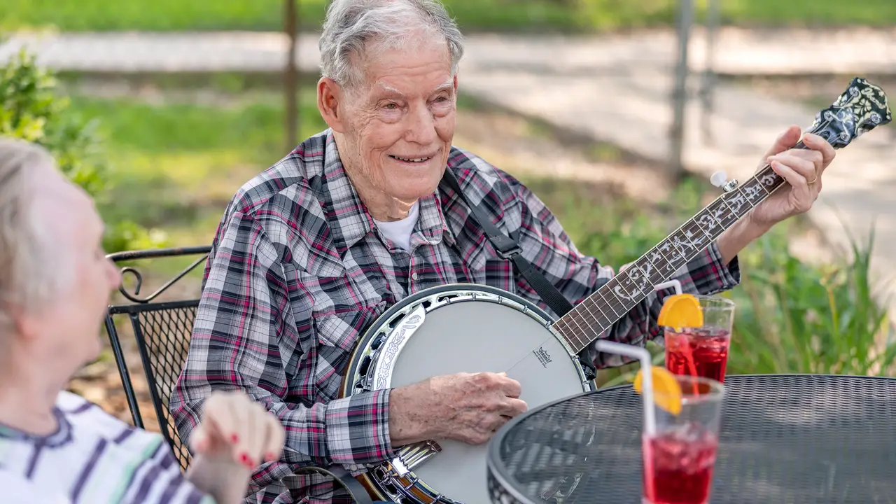 Hillsboro resident playing musical instrument for other residents