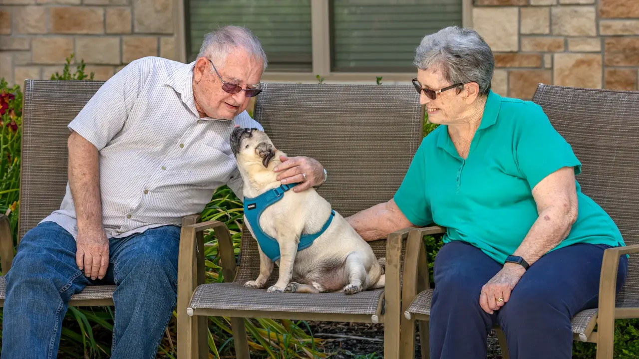 Tiffany Springs residents kissing dog sitting outside