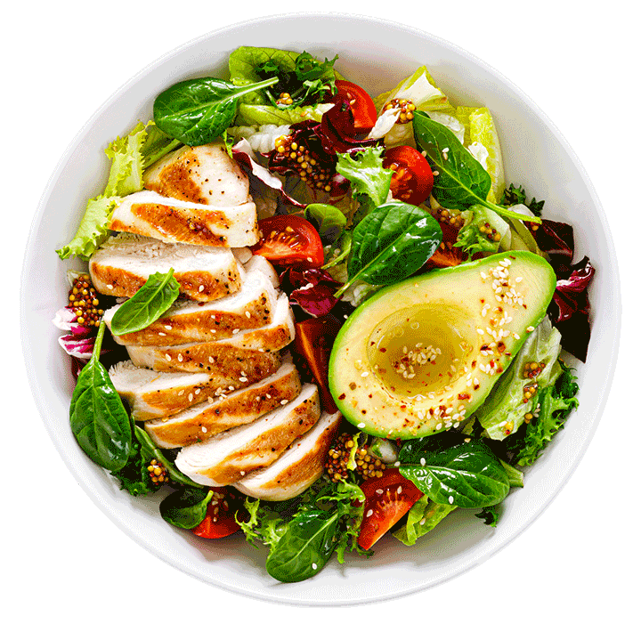 Sliced chicken breasts on a bed of salad