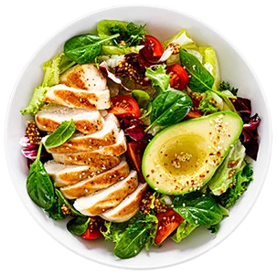 A white bowl filled with a vibrant salad, including grilled chicken slices, half an avocado, mixed greens, cherry tomatoes, and topped with sesame seeds. A light dressing appears to be drizzled over the salad.