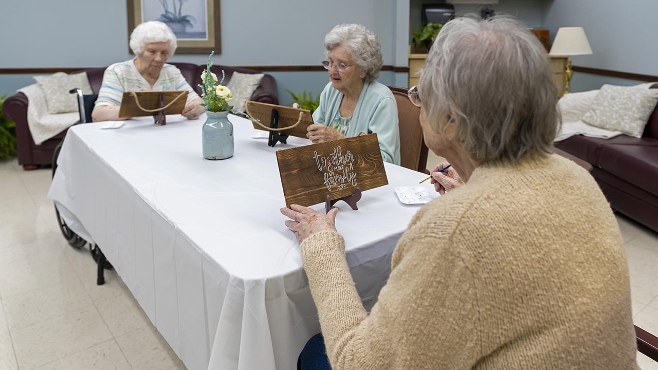 Coulterville senior residents painting a plague