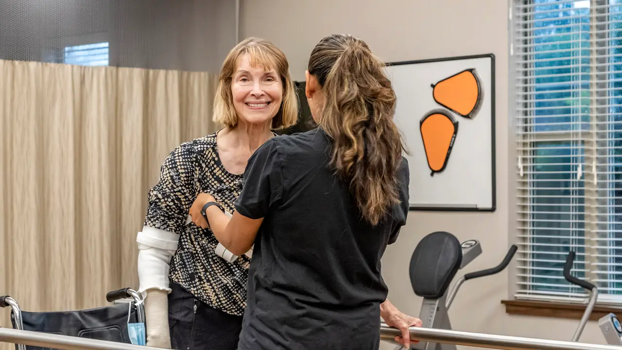 Therapist helping a patient stand up with a gait belt