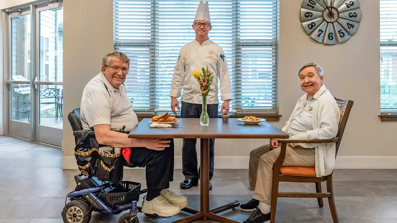 Residents smiling with chef