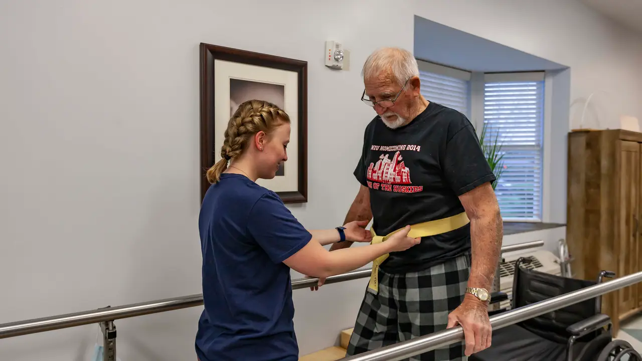 Therapist helping patient walk with gait belt