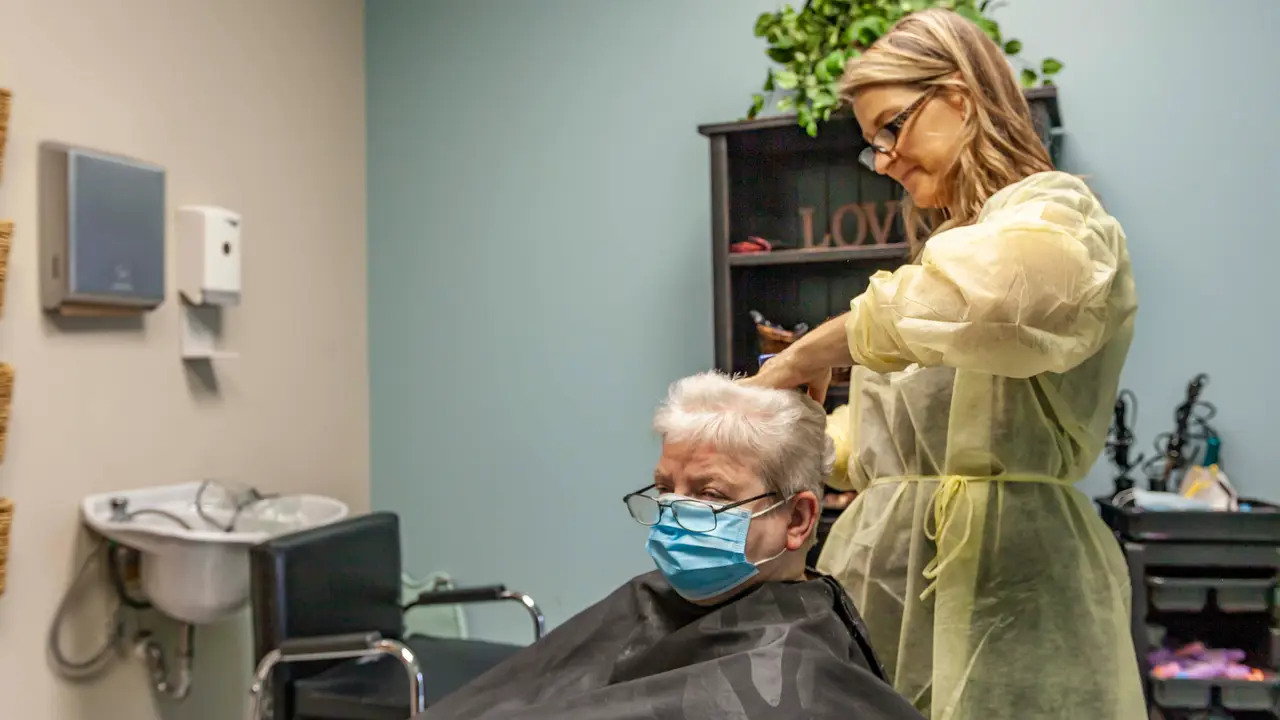 Beautician cutting residents hair