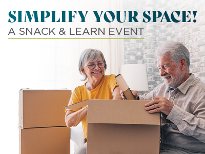 An older couple smiles while packing cardboard boxes in a bright living room. Text above them reads,