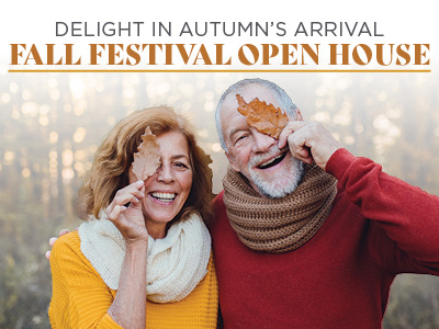 Smiling older couple in cozy sweaters and scarves hold autumn leaves over one eye, standing outdoors. Text above reads, 