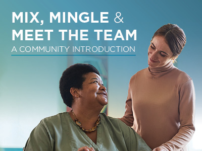 A smiling woman in green scrubs sits while a woman in a light brown sweater stands beside her, smiling and placing a hand on her shoulder—highlighting the warmth of our Assisted Living team. Text above reads,