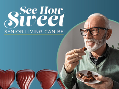 An older man with glasses smiles while holding a plate of chocolates, about to eat one. Beside him is text that reads, 
