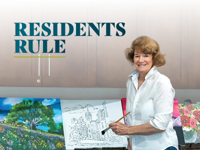 A smiling woman stands at an easel, holding a paintbrush in front of her artwork with colorful paintings beside her. The words 