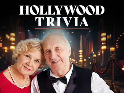 An elderly couple dressed formally smiles in front of a glamorous, dimly lit backdrop with the text “HOLLYWOOD TRIVIA” above them. Velvet ropes and glowing lights create a classic Hollywood atmosphere.