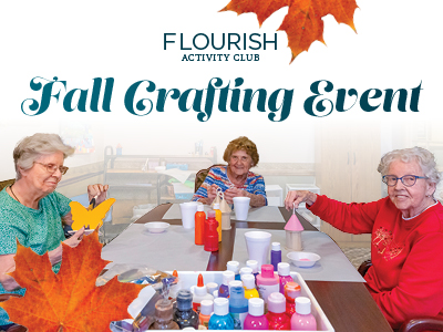 Three elderly women sit at a table doing crafts with colorful supplies. The text above reads 