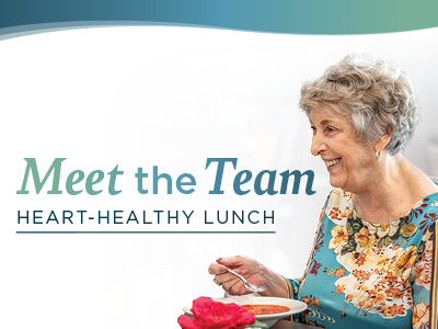 Smiling older woman with short gray hair and a floral top enjoys a meal. Text reads