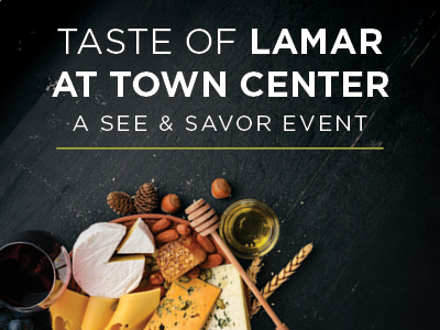 A cheese and charcuterie board with honey, nuts, and wine sits on a dark surface below text that reads, 