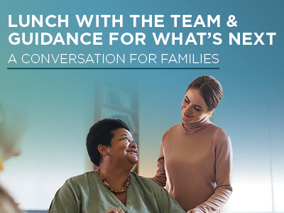 Two women, one seated and one standing, smile at each other warmly. Text above them reads,