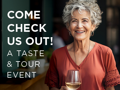 Smiling woman with short curly hair holds a glass of white wine. Text on the image reads: 