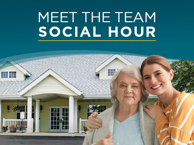 Two women, one older and one younger, stand smiling in front of a yellow house with a sign above them that reads, 