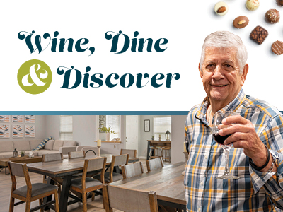 An older man holding a glass of red wine stands smiling in a bright dining area. The text reads, “Wine, Dine & Discover.” Chocolates are displayed at the top right of the image.