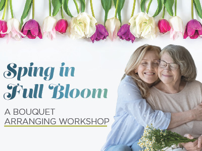 Two women, one older and one younger, smile and hug while arranging flowers. Above them, colorful tulips hang upside down. Text reads: “Spring in Full Bloom – A Bouquet Arranging Workshop.”.
