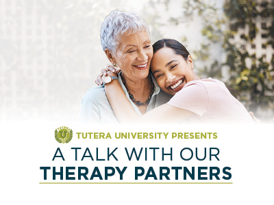 Two women, one older with short gray hair and one younger with dark hair, smile and embrace outdoors. Text reads: 