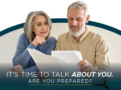 An older woman and man sit together, reviewing documents and smiling. Text over the image reads,