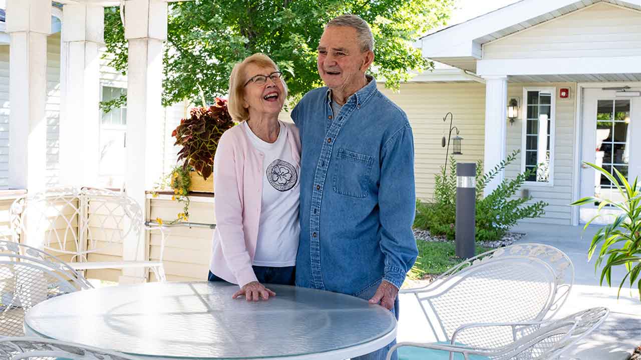 Couple smiling for portrait outside at Eiler Senior Living