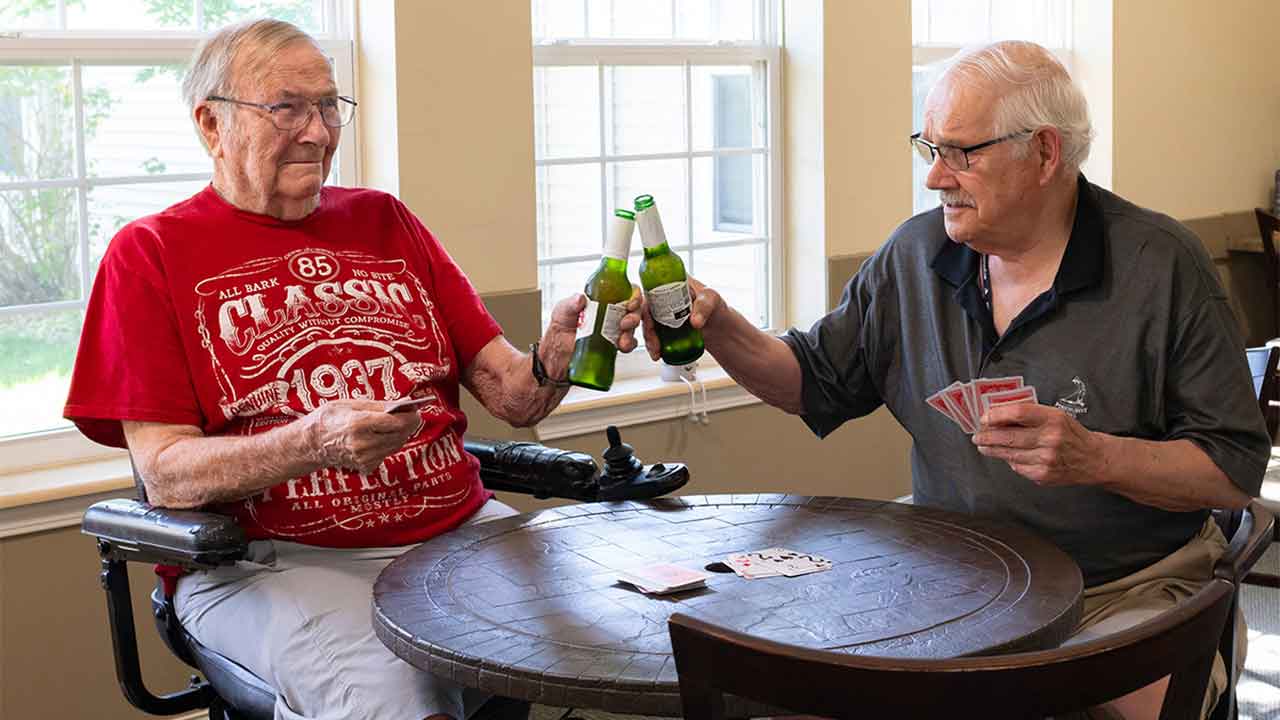 Residents playing cards and drinking at Eiler Senior Living