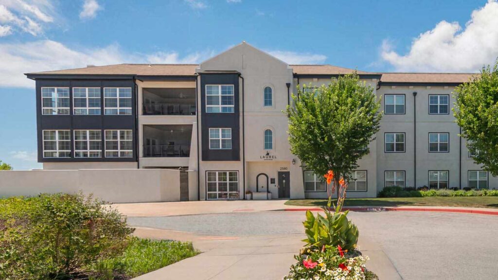Upscale three-story assisted living and memory care building with balconies and large windows at The Laurel at Norterre in Liberty, MO, Clay County.