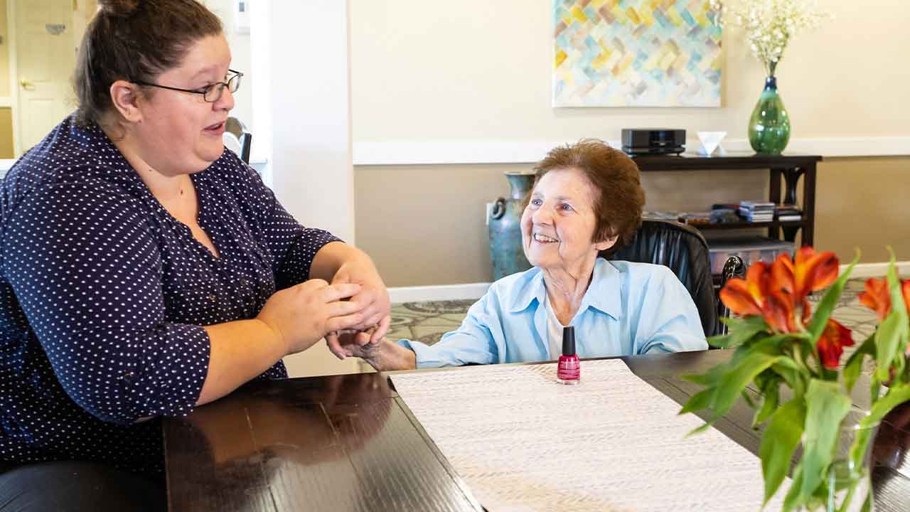 Caregiver painting resident's nails at Morton Senior Living