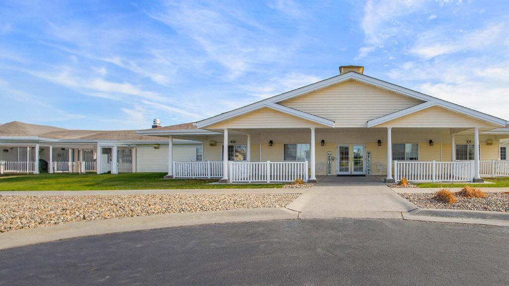 Wide covered porch with rocking chairs at Pathfinder Senior Living Assisted Living in Fremont, NE, Dodge County.