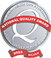 A silver medal-style emblem with a large "Q" in the center, a red banner reading "National Quality Award," and text indicating "2023 Silver" at the bottom, celebrating excellence in Senior Living Community care.