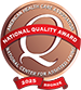 Bronze circular emblem for the 2023 National Quality Award by the American Health Care Association and National Center for Assisted Living, featuring a large "Q" and a red ribbon with the text "Bronze" at the bottom.