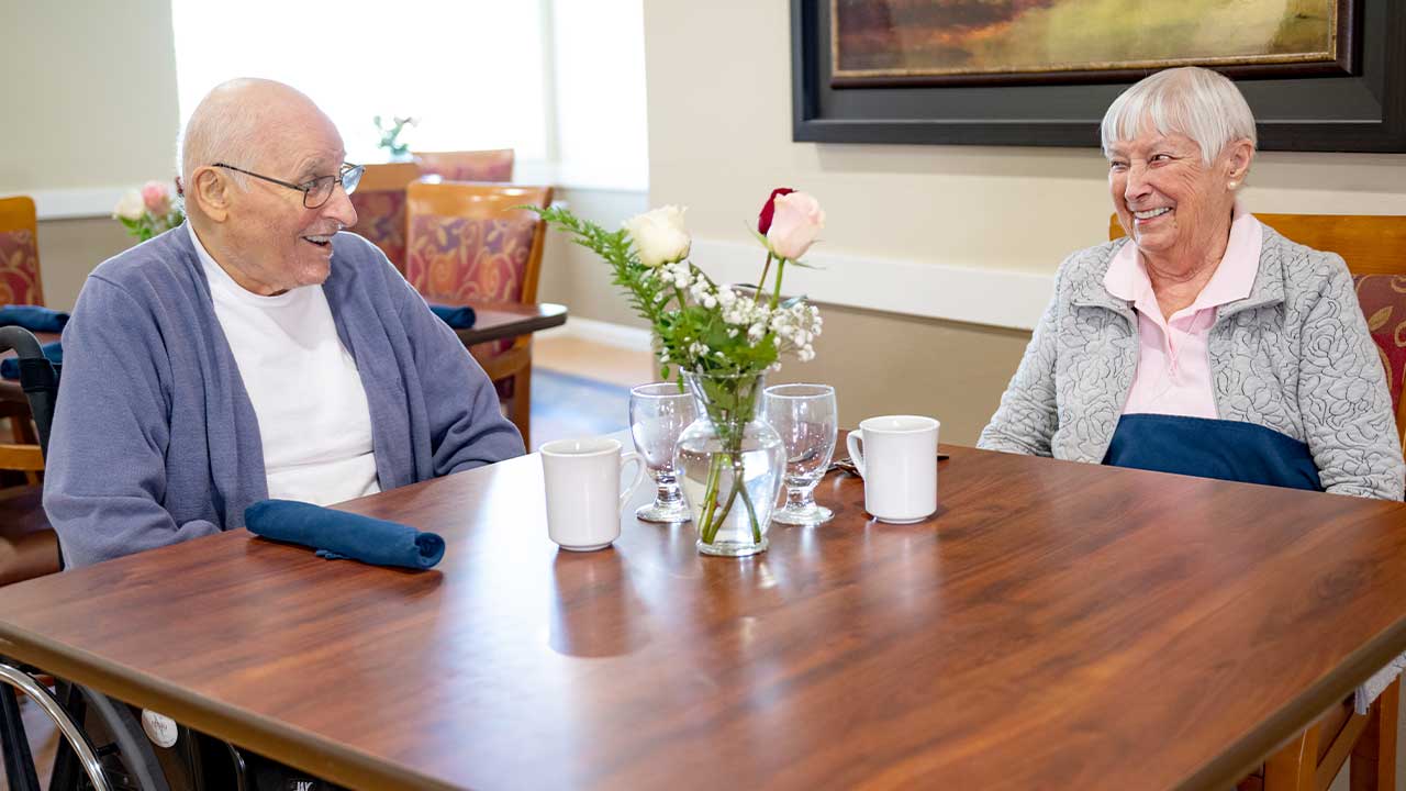 Resident couple enjoying lunch in the dining room at Pathfinder Senior Living