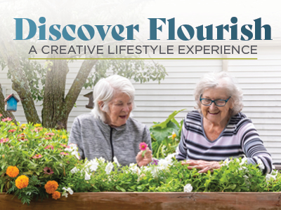 Two older women smile and garden together in a raised flower bed full of colorful flowers, with the text