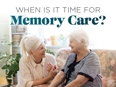 Two women sit on a couch smiling at each other, one younger and one older. Text above them reads, “When is it time for Memory Care?” The setting appears warm and homey with plants and sunlight.