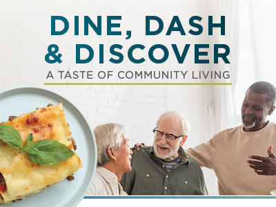 Three seniors smiling and talking together in a bright room, with a plate of lasagna in the foreground. Text reads: