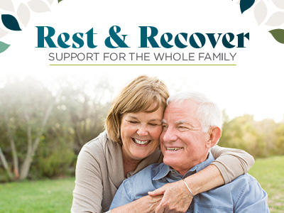 An older woman hugs an older man from behind as they both smile outdoors, enjoying the peace that comes with assisted living. Text above them reads, “Rest & Recover. Support for the whole family.” Leaves frame the top corners of the image.