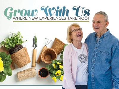 An older smiling couple stands together with gardening tools, plants, pots, and flowers nearby. Text above reads “Grow With Us: Where New Experiences Take Root.” Discover vibrant assisted living in Prairie Village KS.
