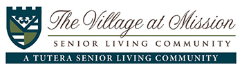 Logo for The Village at Mission Senior Living Community, featuring a green and blue shield crest on the left and stylized text on the right, highlighting assisted living in Prairie Village, KS. 