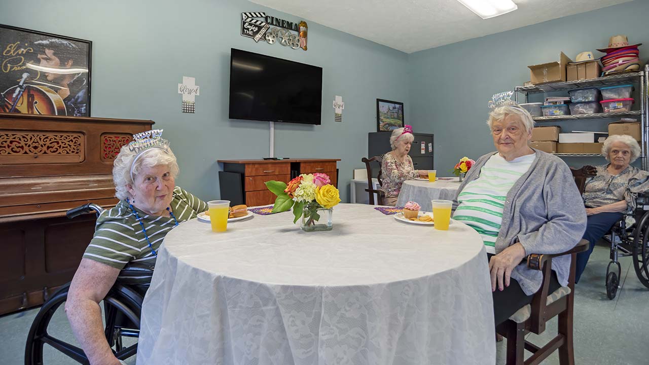 Charlton Place residents in dining hall at table eating cupcakes