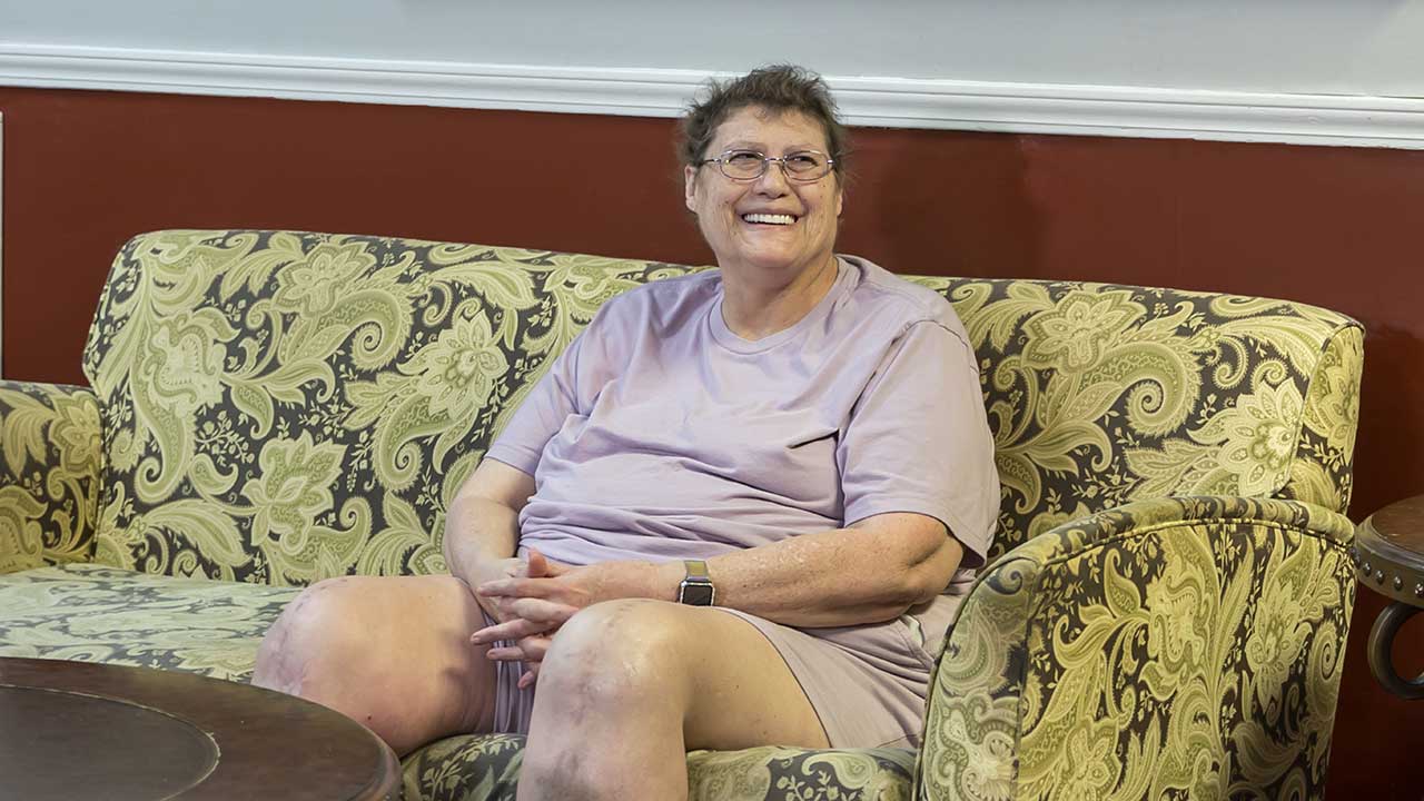 Meridian senior female resident sitting on couch