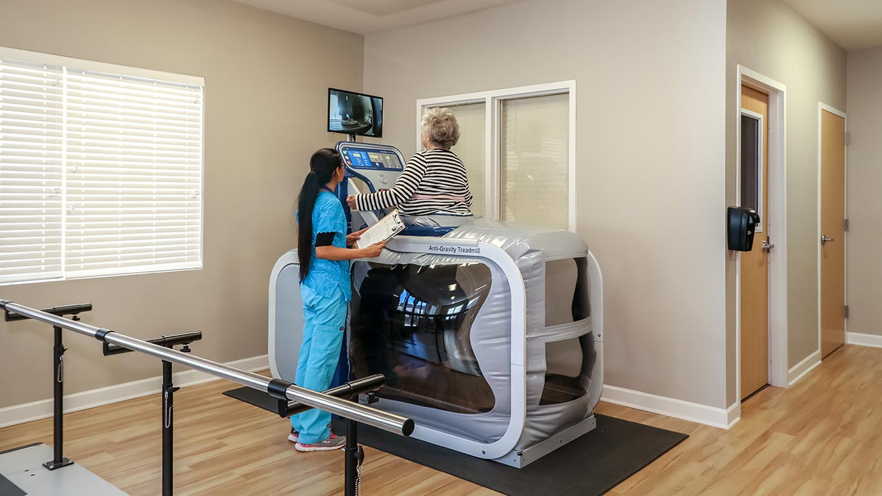 Stratford Commons Rehab helping patient on Anti-Gravity treadmill
