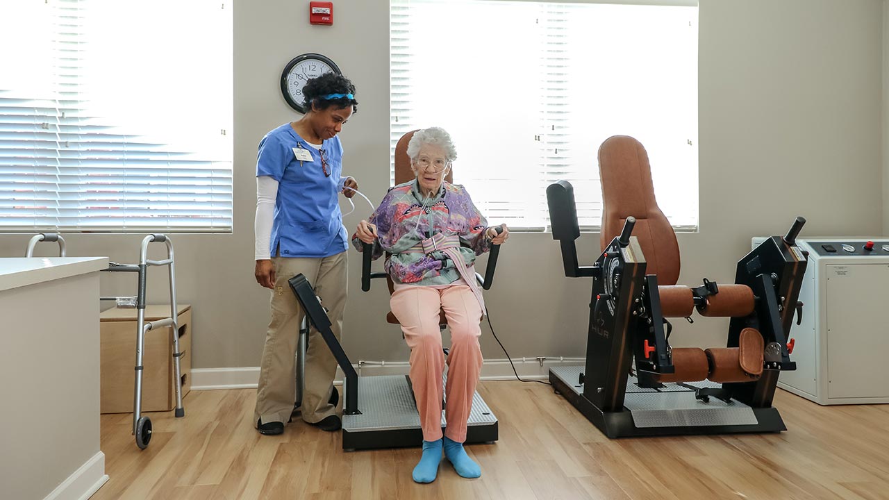 Stratford Commons Rehab staff helping resident on weight machine