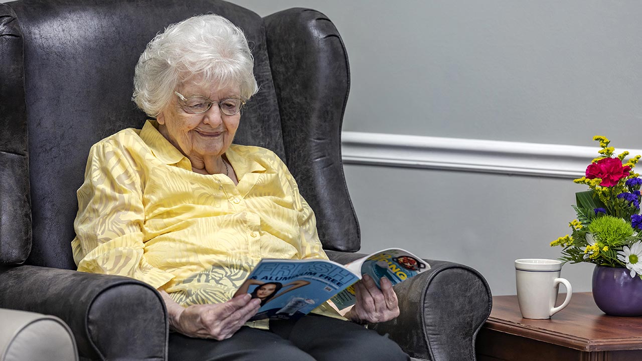 Carlinville senior resident reading a book in common area