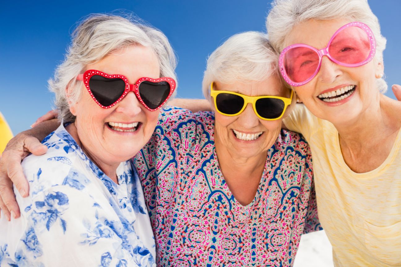 3 smiling females with fun sunglasses on